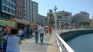 Paseantes  por el puerto deportivo, con el Mercad�n de la Sidra y la Manzana del Festival de la Sidra