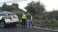 Un agente de tr�fico con el ciclista herido en el lugar en el que se produjo el accidente