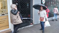 Ana L�pez, responsable de la peluquer�a Fusi�n, habla por tel�fono en la entrada de su negocio, junto a una de las vecinas afectadas