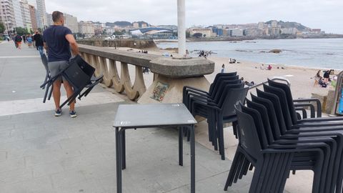 Sillas y mesa del Gasthof apiladas en le paseo marítimo después de que los jóvnes las devolviesen