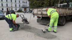 Operarios tapando ayer uno de los socavones en el acceso desde el Paseo de la Estaci�n.