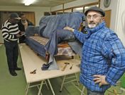 Jes�s Aguayo, en el local donde dos colaboradores tapizan un sof� con pantalones vaqueros . 