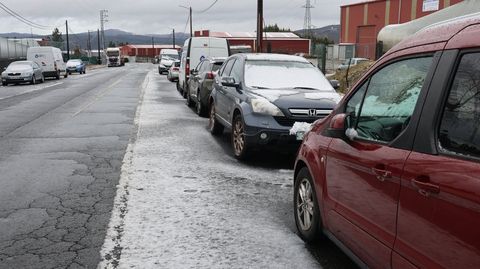 Nieve acumulada sobre veh�culos y en el arc�n en el pol�gono de Os Air�os, en As Pontes.