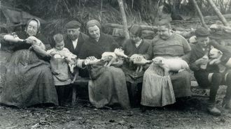 Una familia gallega al completo alimentando a unos cerdos con biber&oacute;n