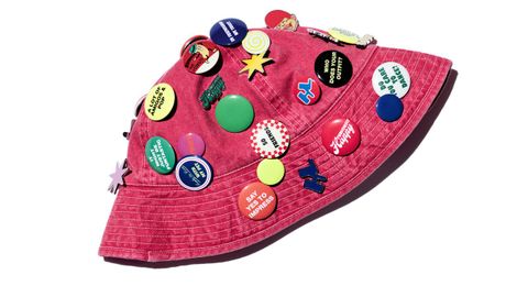Harry Lambert x Zara 50 Aniversario. Gorro con Pins Este gorro tipo bucket en color rosa lavado está cubierto de una densa colección de pines esmaltados y de plástico, todos diferentes entre sí. Los pines presentan símbolos retro y frases como «YES», «Have a Nice Day» y «BEING NORMAL IS BORING». Inspirado en una pieza vintage del archivo personal de Lambert, ha sido reinterpretado con pines nuevos que evocan viajes imaginarios, hallazgos de segunda mano y optimismo noventero. Un moodboard portátil de color, kitsch y sabiduría coleccionada.