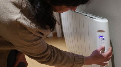 Una mujer programa la calefacci�n en su vivienda, en foto de archivo