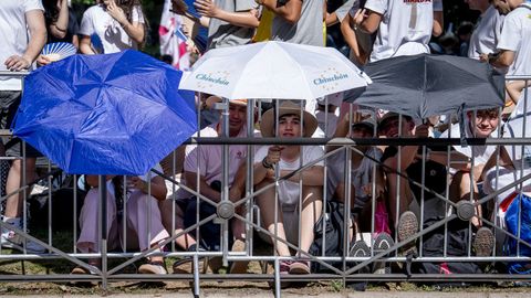 Algunos de los congregados en las inmediaciones de la Plaza de Lima, donde se celebrar� la Vigilia de Oraci�n, se cubren con paraguas ante el intenso sol de la capital.