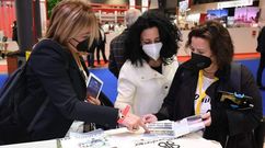 Lita Torres y M�nica Castromil muestran a la alcaldesa de Cee, en el centro, las gu�as de �20xVinte�, en Fitur.