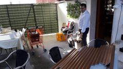 El propietario del restaurante Penela junto a la puerta por la que entraron los ladrones al local, en una terraza situada en un lateral del edificio