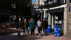 Personas con mascarillas, pasando por el centro urbano de Pontevedra
