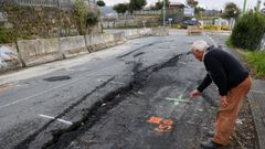 Un vecino de la zona muestra la parte del vial en el que se ve el corrimiento de tierras que oblig� a cerrar la  DP-4803 en la playa de Lago.