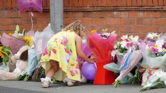 Una ni�a deja flores como tributo a la peque�a Olivia, asesinada de un tiro en su casa de Liverpool