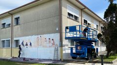 Dos de los autores de la obra, afanados con el mural.