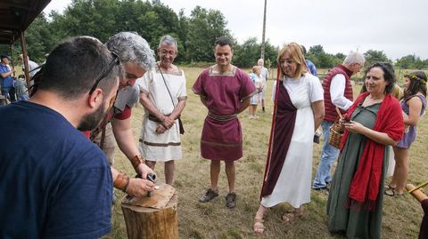 Un integrante de Caetra Lucensium imprime una moneda en la fiesta Floralia, con el alcalde Luis Fern�ndez Guiti�n y los concejales Raquel Arias e Iv�n Armesto