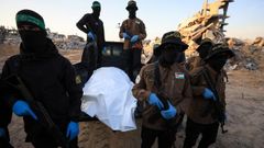 Militantes de Hams y de la Yihad Islmica esperan por los miembros de la Cruz Roja para entregar el cuerpo de uno de los rehenes israeles