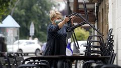 Fotograf�a de archivo de una camarera con mascarilla colocando una terraza en la zona de la Compa��a
