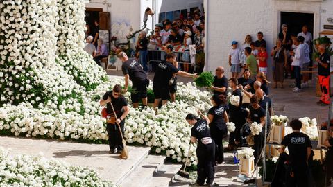Varios operarios ultiman los arreglos florales en el exterior de la iglesia de San Giorgio Martire, en Locorotondo (Italia)