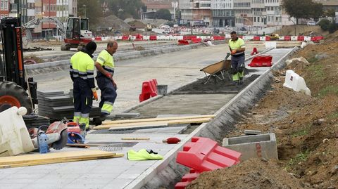 Operarios componiendo una de las aceras en O Bertn el pasado viernes.