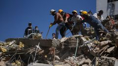 Personas trabajan en labores de rescate en una edificaci�n colapsada por el terremoto en Colombia.