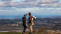 Una pareja intenta protegerse del viento en Gij�n