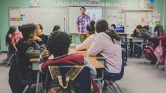Niños atienden a la explicación de un profesor en el aula