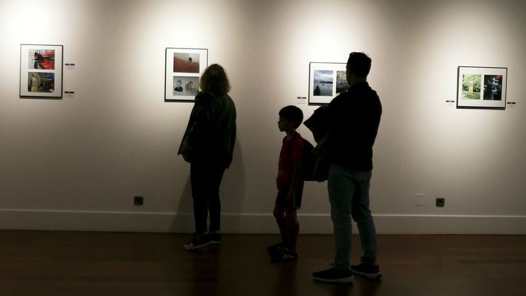 Una familia visita la muestra fotogr�fica del 8M.