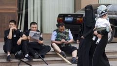 Mujeres de la etnia uigur pasan por delante de polic�as chinos en la ciudad de Urumqi, en la provincia de Xinjiang