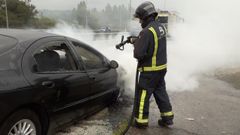 Bombero sofocando el incendio en un coche averiado en la �Y�