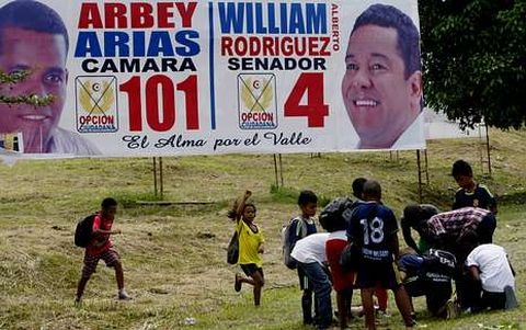 Un grupo de niños juega junto a vallas publicitarias en la ciudad de Buenaventura.