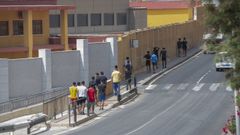 Un grupo de menores migrantes no acompañados se dirige junto a su educador a la nave donde están alojados cerca de la frontera de El Tarajal.