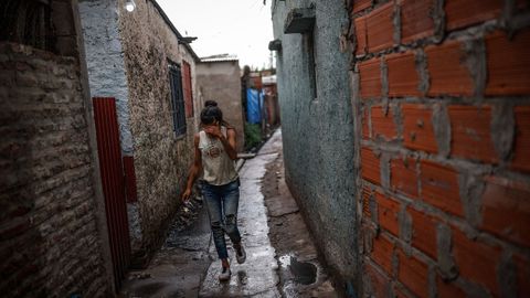 Una mujer camina por una calle del barrio marginal Puerta 8 donde se vendi� la coca�na adulterada.