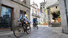 Peregrinos en bicicleta por la ciudad medieval