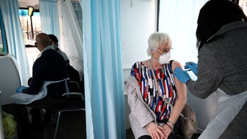 Una enfermera vacunando a una paciente 