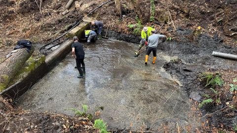 Trabajadores municipales y vecinos limpiando ayer el azud y la captaci�n de agua en San Miguel, en Vilamart�n de Valdeorras