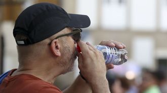 Un hombre se refresca en plena ola de calor. 