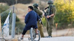 Un ni�o palestino, este martes paseando frente a los soldados isrealies en Umm al-Khair.