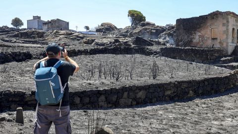Un ciudadano fotograf�a los alrededores calcinados del municipio de Fermoselle.