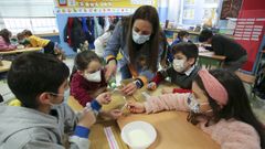 La profesora Carmen Pena con sus alumnos realizando un experimento con agua y leche