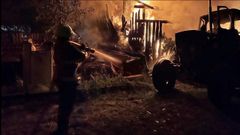 Un bombero trata de apagar el fuego en una vivienda da�ada por los bombardeos de Rusia en la regi�n de Le�polis, en una imagen del servicio de emergencias ucraniano