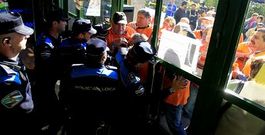 Agentes de la Polic�a Local de Nigr�n cerrando la entrada al Concello a un concurrido grupo de afectados por las preferentes.