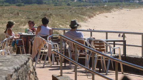 Ba�istas toman el sol en un chiringuito de la playa de A Lanzada.