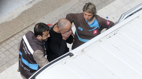 Los servicios de emergencia acompaan a un hombre consternado por lo ocurrido. 