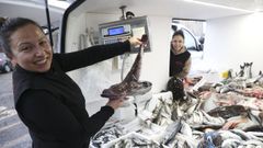 Juana y Luc�a, al fondo, con una de las dos furgonetas repletas de pescado que llevan por barrios de Santiago y municipios lim�trofes
