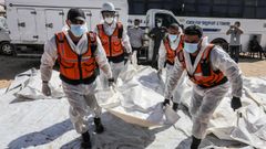 La Defensa Civil de Gaza traslada cadveres palestinos para su entierro tras un ataque israel.