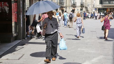 Un hombre se protege con un paraguas del calor en Pontevedra.