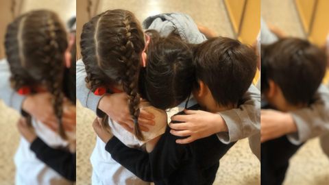 Tres hermanos del centro coru��s San Jos� de Calasanz liberan en un abrazo sus emociones despu�s de haber recibido la visita de un familiar. De momento, padres e hijos pueden verse, pero no besarse ni tocarse