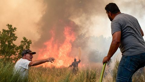 Los vecinos de la Guarda colaborando este martes en las tareas de extinci�n.