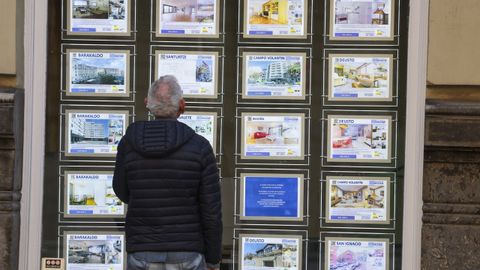 Una persona observa los carteles de una inmobiliaria