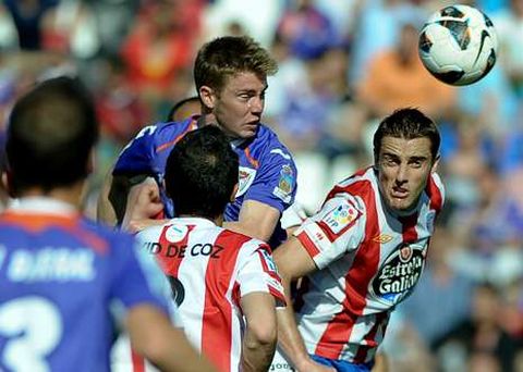 Fernando Seoane, que conform� junto a Javi Rey la pareja de mediocentros, en pugna por un bal�n a�reo con un jugador alcarre�o.