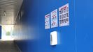 Pasillo de El Requexón, con un dispensador de jabón y carteles informativos